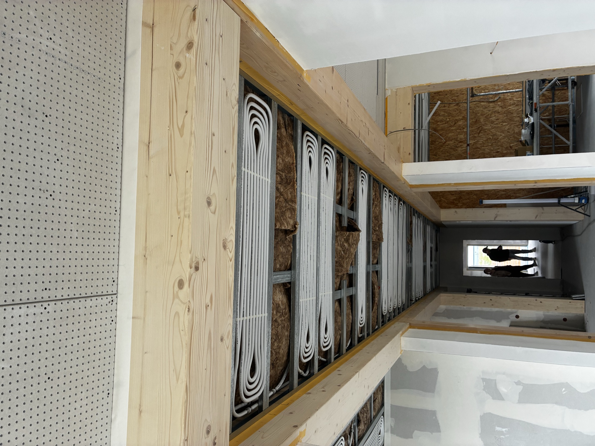 Offener Deckenaufbau mit Rohrleitungen, Dämmung und Lochplatten